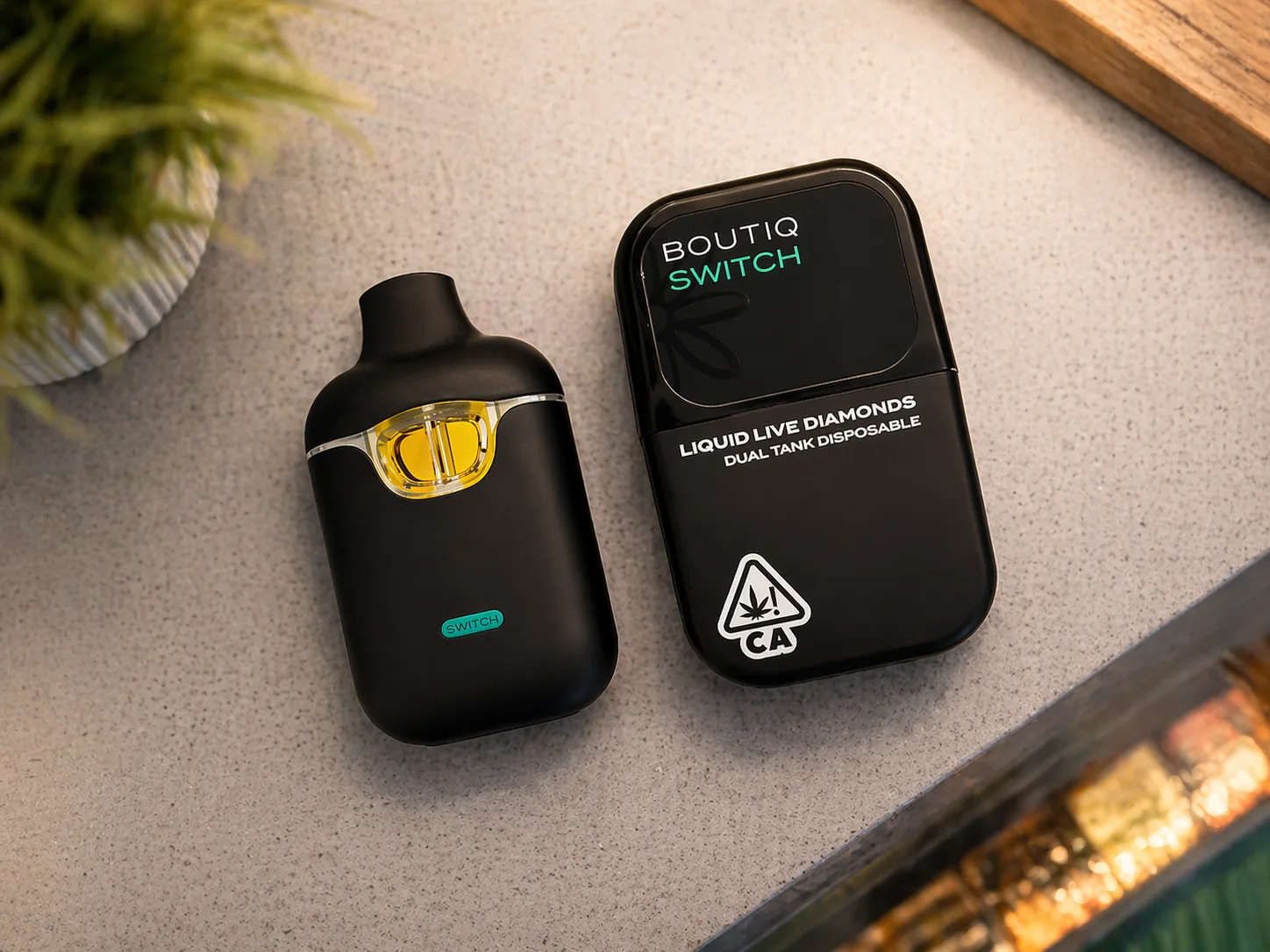Top view of Boutiq Switch dual tank disposable vape device and packaging